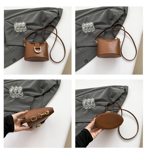Detail view of brown leather bucket bag with adjustable strap and metal D-ring buckle