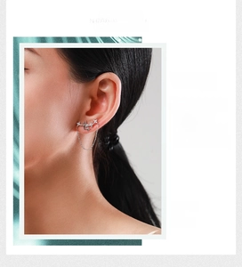 Detail of S925 sterling silver star stud earring with hanging tassel on a female model
