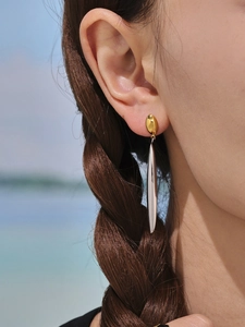 Detail of two-tone geometric drop earrings with gold studs and silver streamers on a model
