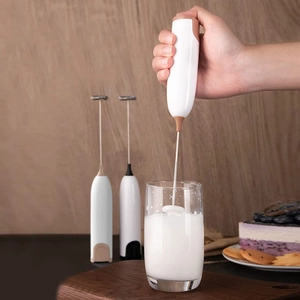 Electric handheld milk frother for coffee foam with stainless steel whisk in action
