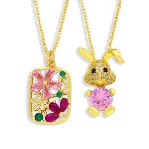 Détail du pendentif hibou et collier lapin avec pierres roses et motifs floraux