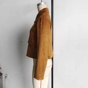 Detail view of brown faux suede jacket featuring a large flap pocket and matte texture