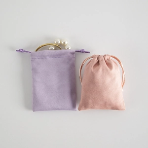 Microfiber suede drawstring jewelry pouches in purple and pink with pearl necklace