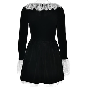 Vue arrière d'une robe en velours noir avec dentelle blanche aux poignets et à l'ourlet
