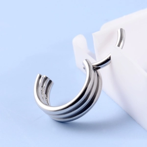 Macro shot of silver triple-layered metal ring showing polished texture and clean lines