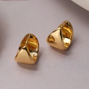Polished gold plated triangular hoop earrings for women on soft fabric background