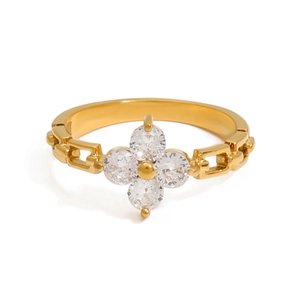 Gold clover ring with zircon crystals and chain band design on white background