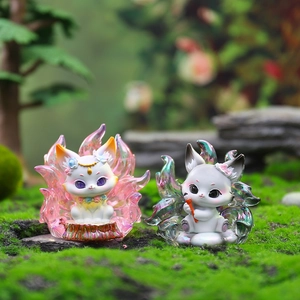 Close-up of lucky fox figurines with gradient tails on mossy rock in forest scene