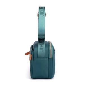 Deep green water-resistant nylon shoulder bag with wide branded strap and side zippers
