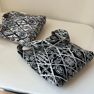 Close-up of geometric bird embroidery on vintage canvas underarm bag with high-density stitching