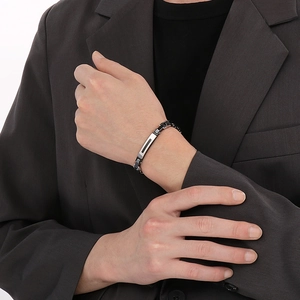 Detail of men's link bracelet featuring matte black and polished silver stainless steel