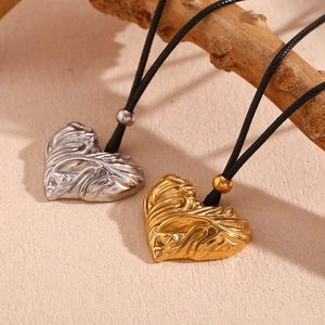 Folded heart pendant necklace in 18K gold and silver finishes on black cord