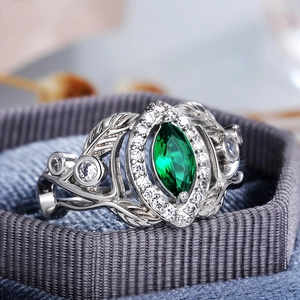 Macro view of marquise-cut green zircon ring with silver filigree leaf band details