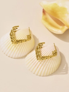 Detailed view of golden irregular geometric hoop earrings on natural seashells