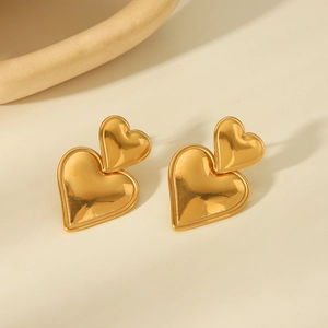 Detailed close-up of 18K gold plated heart stud earrings with a textured hammer finish