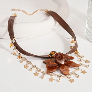 Detail of vintage brown resin flower choker necklace with gold fringes and butterfly charms