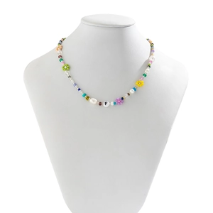Detail of colorful beaded choker with acrylic flowers and freshwater pearls on white bust