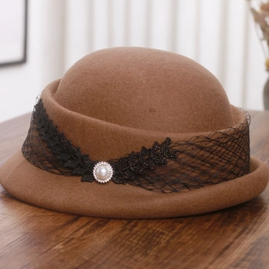 Détail du béret en laine marron foncé avec dentelle noire élégante et perle ornée