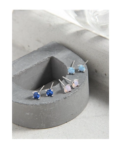 Macro detail of geometric 925 sterling silver stud earrings in blue and opal colors