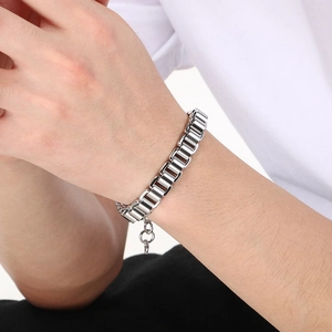 Gros plan d'un bracelet gourmette en acier inoxydable argenté au poignet d'un homme