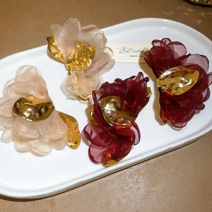 Detail of elegant chiffon flower hair clips in champagne and burgundy with gold accents