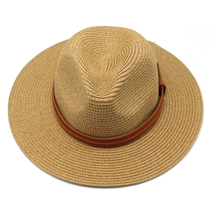 Détail d'un chapeau de paille à sommet plat avec ruban décoratif en cuir marron