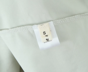 Détail de l'étiquette de taille intérieure S et 10 sur le tissu de la robe menthe
