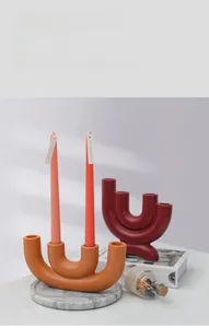 Detail van de minimalistische U-vormige keramische kandelaar met matte afwerking voor decor