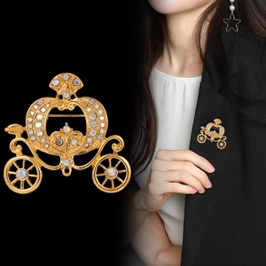 Vintage golden pumpkin carriage brooch with sparkling crystals on a black suit jacket