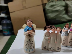 Detailed resin friendship sculpture with sisters holding flowers and engraved text