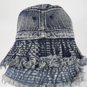 Dettaglio del cappello pescatore in denim lavato con bordi sfilacciati e stile vintage