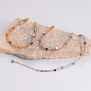 Three minimalist double-layered snake chain bracelets in gold, silver, and rose gold finishes