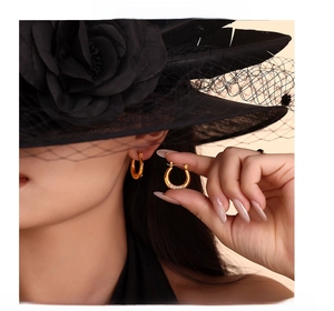 Close-up of golden U-shaped earrings with micro-inlaid cubic zirconia on a model