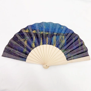 Detailed top view of a vintage folding fan featuring Van Gogh's Starry Night painting