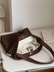 Macro detail of the houndstooth tweed tote interior with fabric lining and side brand label