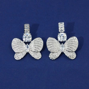 Elegant silver butterfly earrings with sparkling cubic zirconia on a blue background