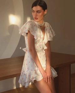 Détail de robe florale à col en V avec manches à volants et tissu en mousseline blanche