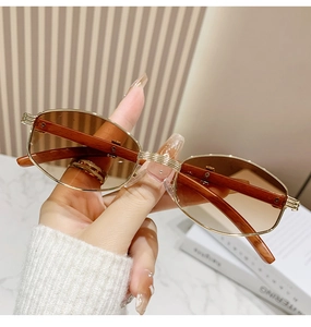 Details einer Vintage-Oval-Sonnenbrille mit goldenem Metallrahmen und braunen Holzbügeln