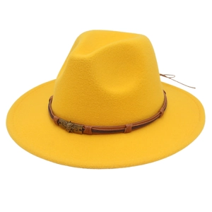 Detail of yellow fedora hat with brown braided band and vintage skull metal ornament
