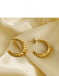 Detail of 18K gold-plated stainless steel hoop earrings with elegant spiral texture