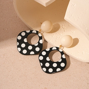 Detail of vintage acrylic geometric square earrings with black and white polka dots