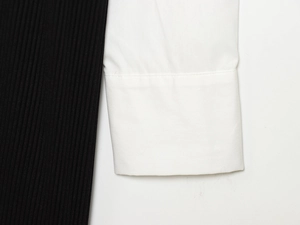 Dettaglio in maglia a coste nere e popeline di cotone bianco su abito a maniche lunghe
