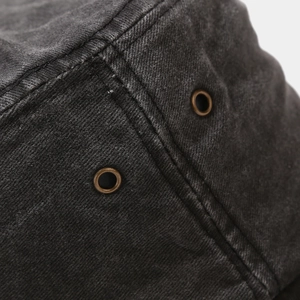Macro shot of washed gray cotton fabric with vintage metal eyelets and reinforced stitching