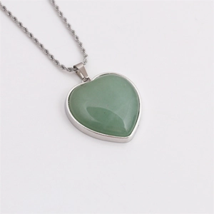 Green heart crystal pendant with silver twisted chain on white background