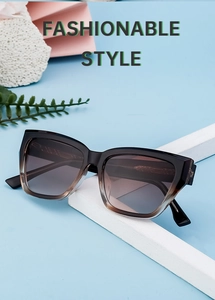 Detail view of fashionable cat-eye sunglasses with gradient lenses and dark brown frame