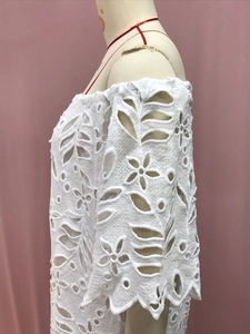 Detailansicht der weißen floralen Spitzenstickerei und der Mesh-Stoffstruktur