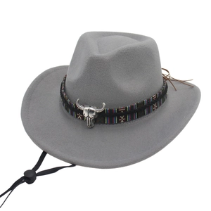 Dettaglio cappello cowboy grigio con emblema testa di toro e fascia in stile etnico