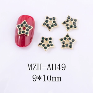 Détails macro de charms pour ongles en forme d'étoile avec strass verts et métal doré