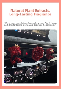 Close-up of red flocked bear and peony flower aromatherapy diffusers on car air vent