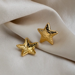 Textured 18K gold plated stainless steel star stud earrings on elegant silk background